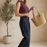 graced The Cinch Side Top in winetasting cotton with side tie detail worn by a smiling woman with dark denim jeans
