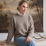 graced crew neck sweater in taupe worn by a woman with a white collared shirt underneath and light blue jeans