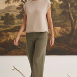 A model wearing graced The Darcy dark olive wide-leg pants with pocket details and a beige sleeveless knit top.