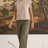 A model wearing graced The Darcy dark olive wide-leg pants with pocket details and a beige sleeveless knit top.