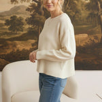 graced Eloise ivory crew neck sweater with dropped shoulders and ribbed hem worn with blue jeans