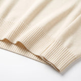 Close-up of the wide ribbed hem on a cream-colored graced Eloise crew neck sweater made from a soft wool blend knit.