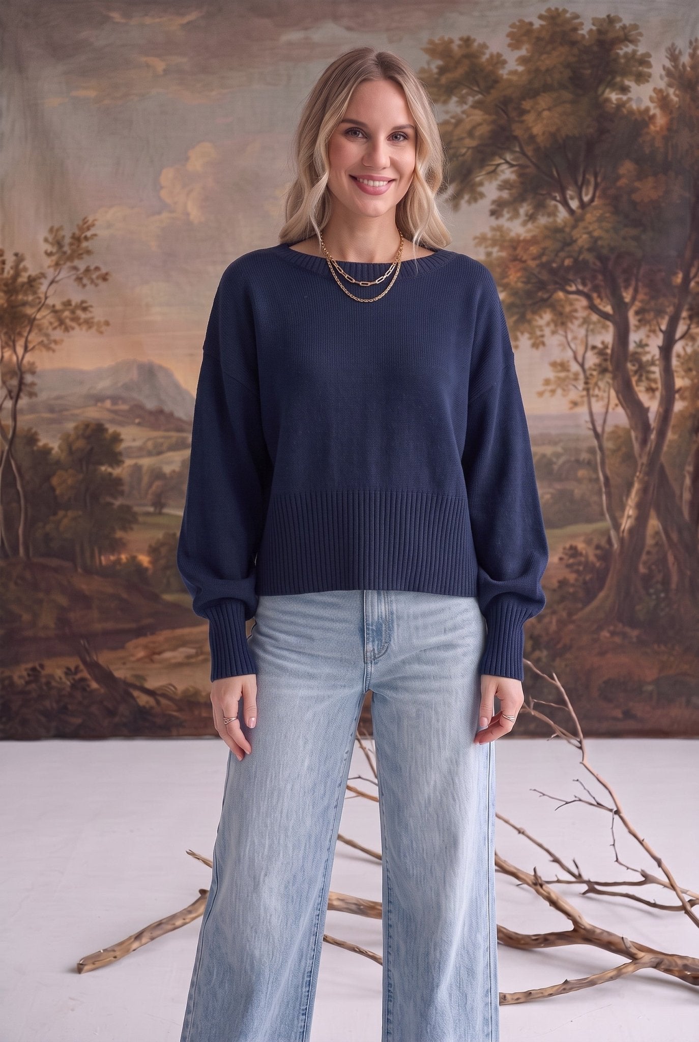 Model wearing a navy graced Eloise crew neck sweater with dropped shoulders and ribbed cuffs paired with light denim