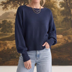 graced Eloise navy crew neck sweater with dropped shoulders and ribbed hem worn by a woman with light blue jeans