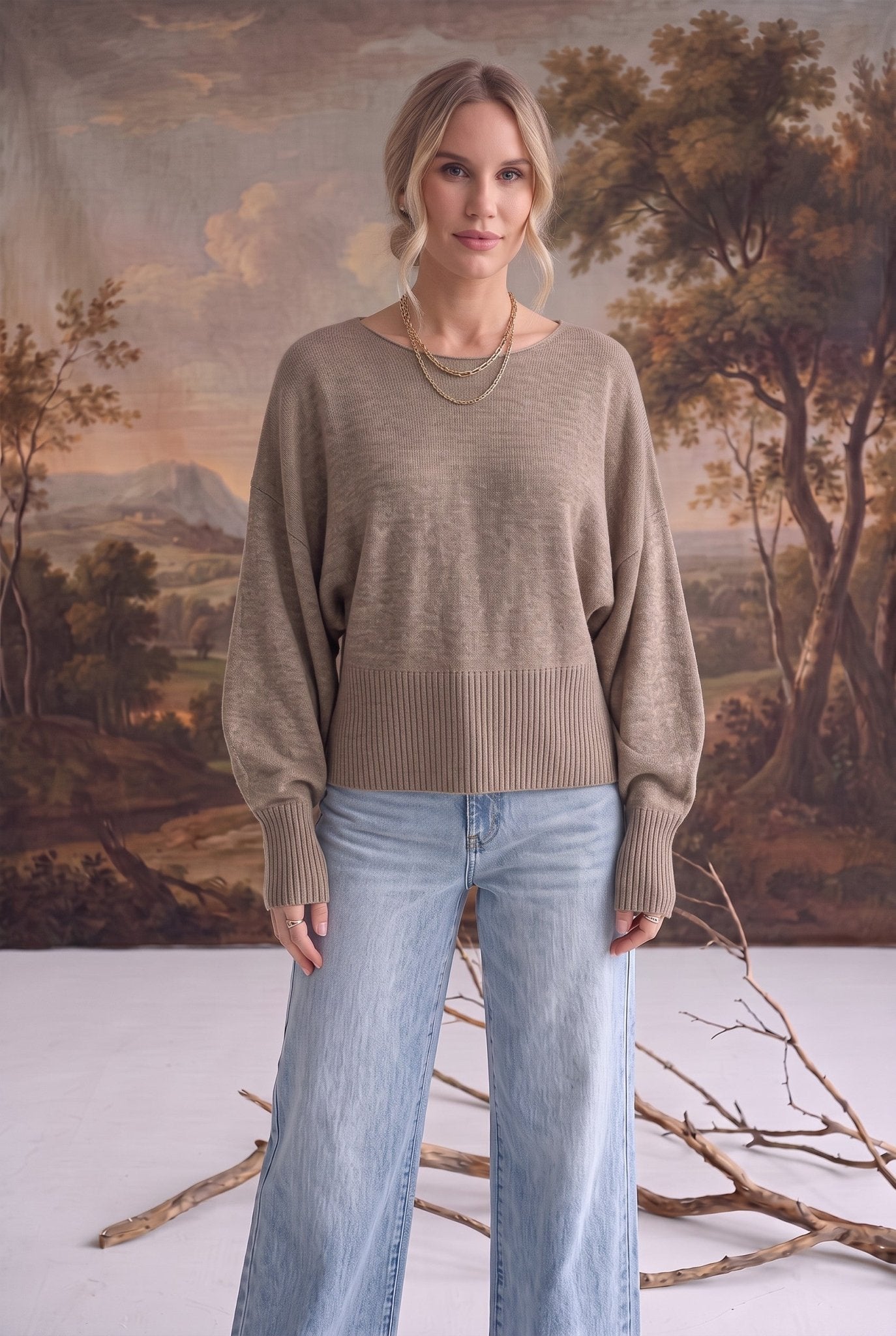 Model wearing a taupe graced Eloise crew neck sweater with drop shoulders and wide ribbed cuffs and hem.