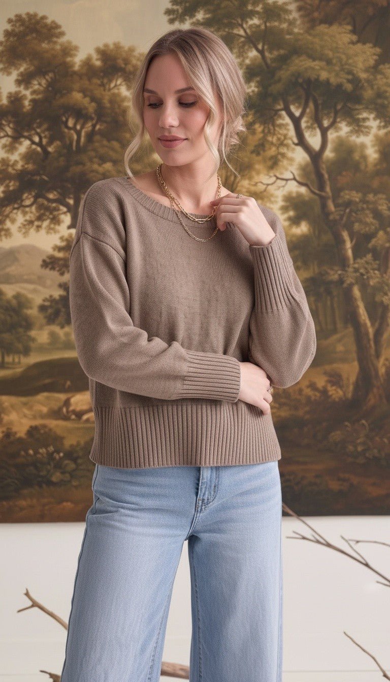 Model wearing a taupe graced Eloise crew neck sweater with drop shoulders and wide ribbed cuffs and hem.