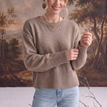 graced Eloise taupe crew neck sweater with drop shoulders and ribbed cuffs worn by a woman with light blue jeans