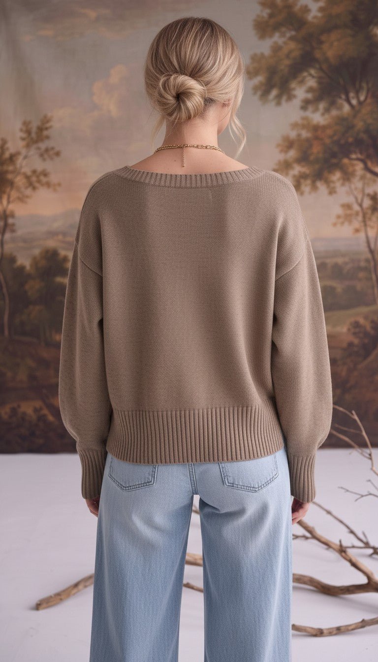 Back view of a woman wearing a graced taupe Eloise crew neck sweater with drop shoulders and wide ribbed hem.