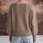 Back view of a woman wearing a graced taupe Eloise crew neck sweater with drop shoulders and wide ribbed hem.