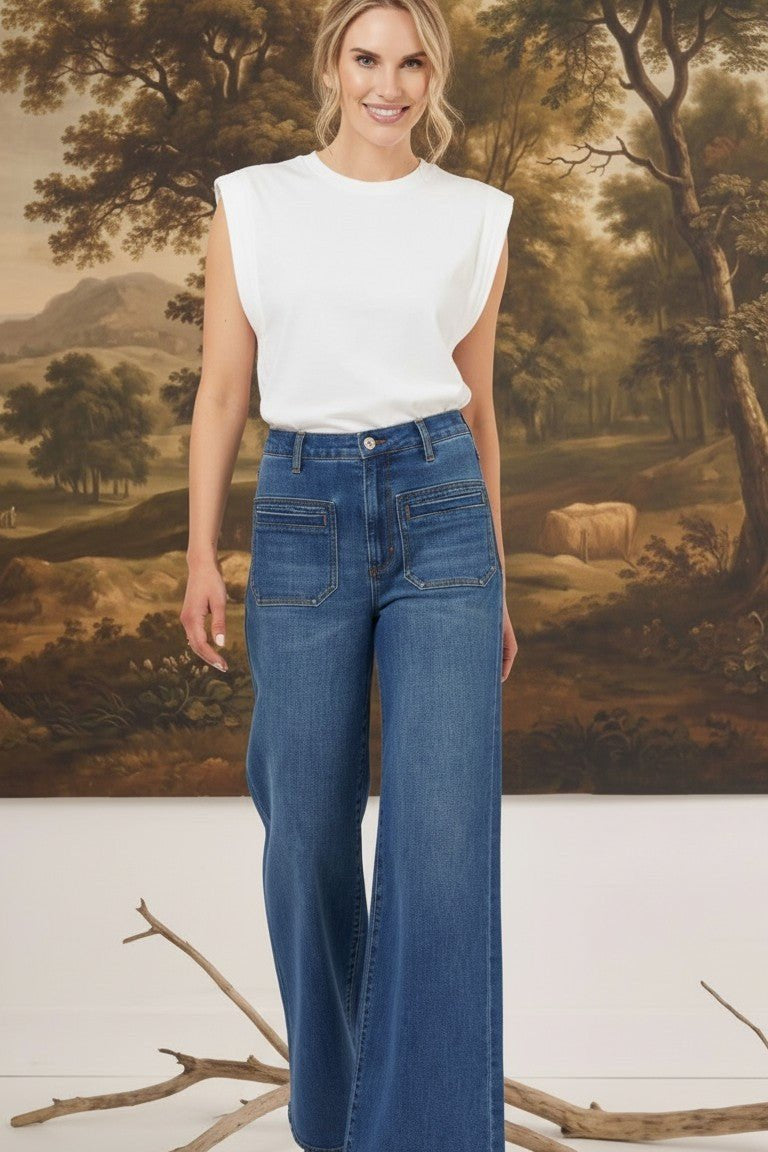 graced Emerson patch pocket relaxed flare jeans in medium wash denim worn with a white sleeveless top