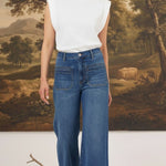 graced Emerson patch pocket relaxed flare jeans in medium wash denim worn with a white sleeveless top