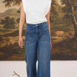 graced Emerson patch pocket relaxed flare jeans in medium wash denim worn with a white sleeveless top