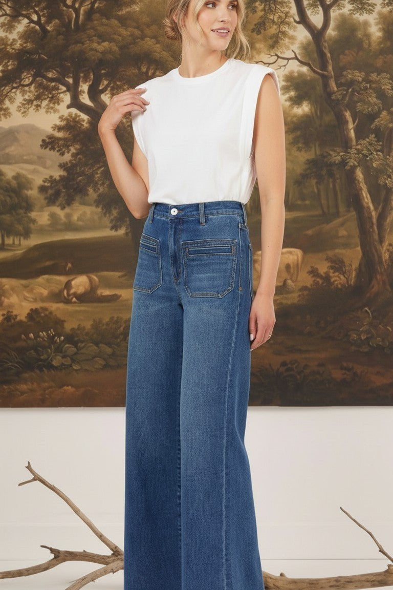 Model wearing graced Emerson relaxed flare jeans with patch pockets and a white sleeveless top