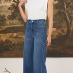 Model wearing graced Emerson relaxed flare jeans with patch pockets and a white sleeveless top