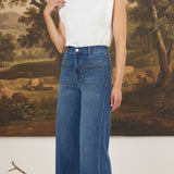 Model wearing graced Emerson relaxed flare jeans with patch pockets and a white sleeveless top