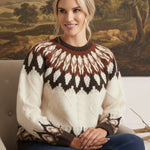 graced Fair Isle cable knit sweater in cream and brown worn by a smiling woman sitting in a chair