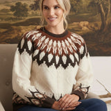 graced Fair Isle cable knit sweater in cream and brown worn by a smiling woman sitting in a chair