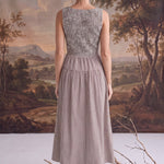 Back view of a graced Harper smocked gingham midi dress in brown and white, featuring a fitted bodice and midi length.