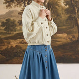 graced cream cotton blend jacket with balloon sleeves worn by a model in front of a landscape painting