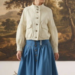 graced cream cotton blend jacket with balloon sleeves and button front worn by a model with a blue denim skirt