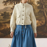 graced cream cotton blend jacket with balloon sleeves and button front worn by a model with a blue denim skirt