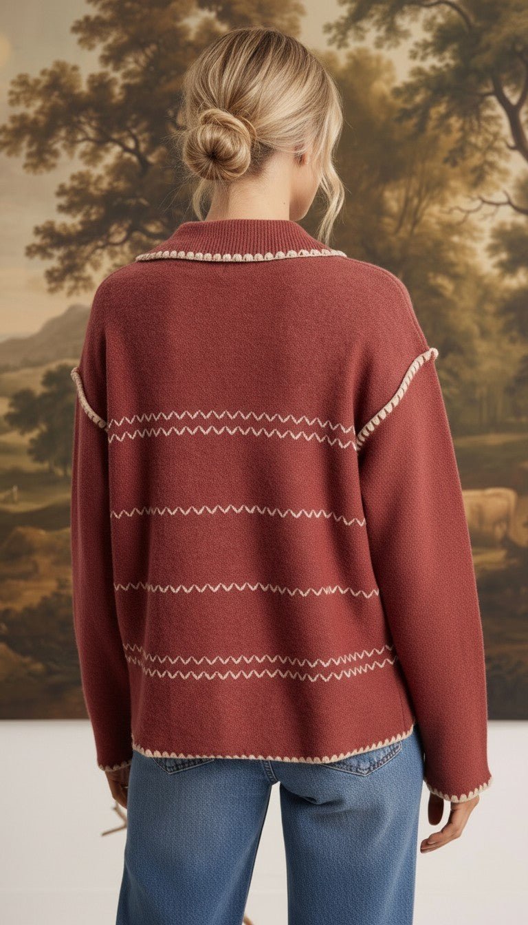 Back view of a woman wearing the graced Jenna Whipstitch Sweater in rust red with cream contrast embroidery details.