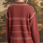 Back view of a woman wearing the graced Jenna Whipstitch Sweater in rust red with cream contrast embroidery details.
