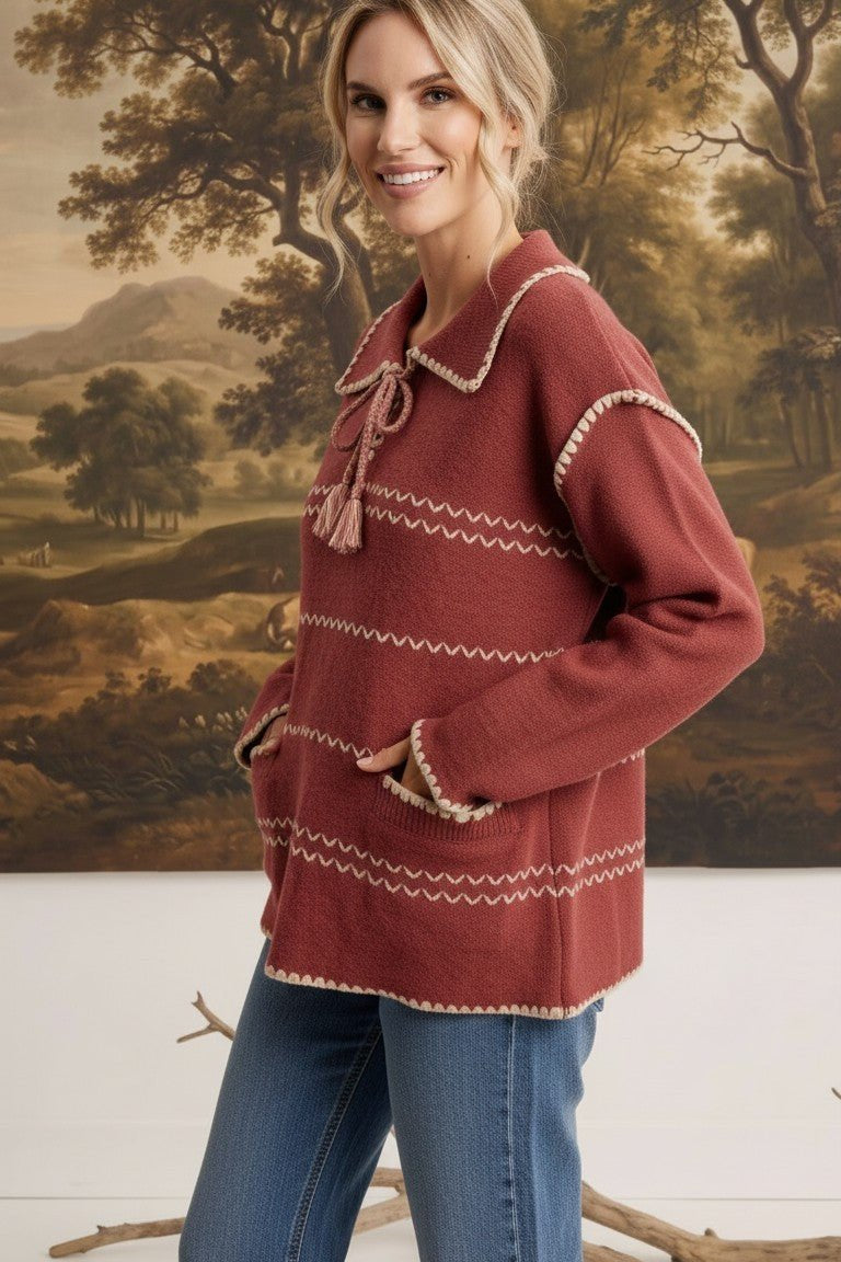 graced Jenna Whipstitch Sweater in rust red with contrast embroidery, collar, and pockets worn by a smiling model