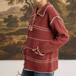 graced Jenna Whipstitch Sweater in rust red with contrast embroidery, collar, and pockets worn by a smiling model