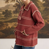 graced Jenna Whipstitch Sweater in rust red with contrast embroidery, collar, and pockets worn by a smiling model