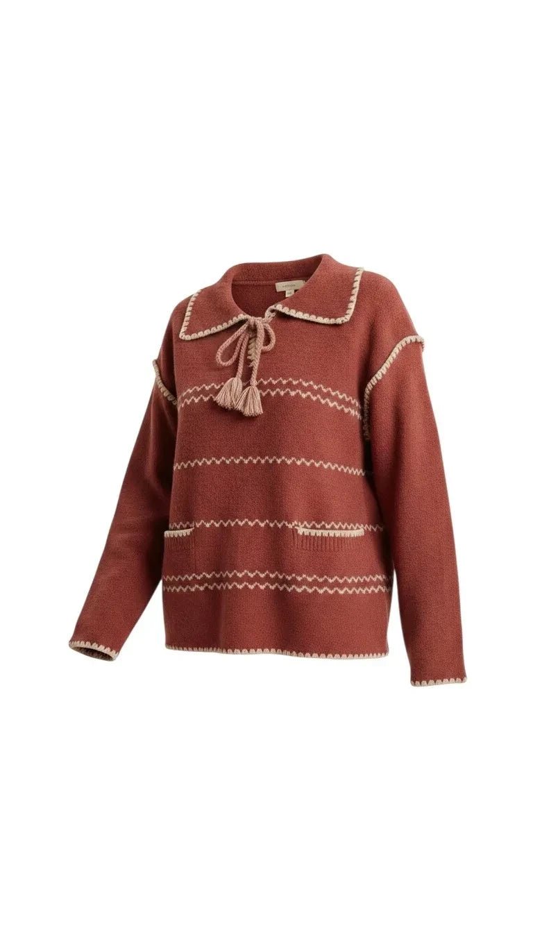 graced Jenna Whipstitch Sweater in rust red with cream contrast embroidery, collar, tassel tie, and front pockets.