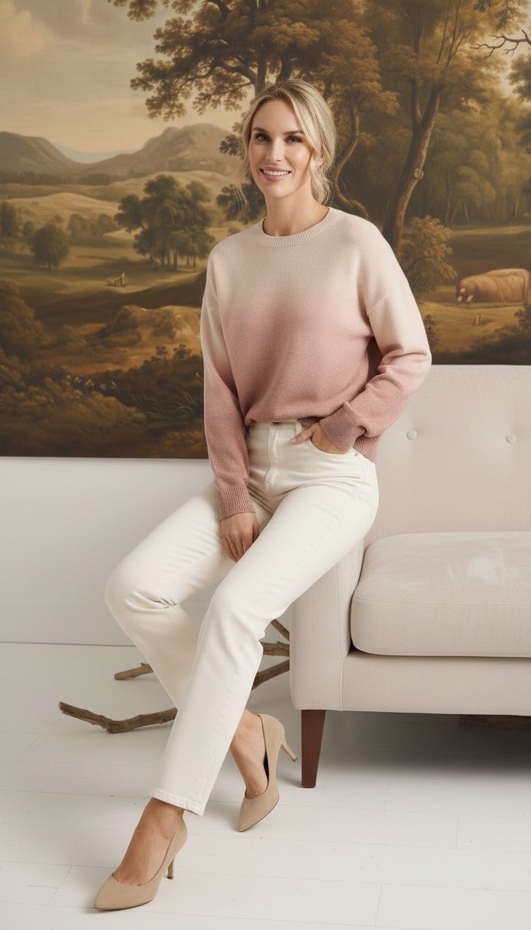 graced The Joan Gradient Sweater in soft pink and cream, worn by a model with white jeans and beige heels.
