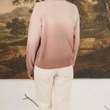 graced The Joan Gradient Sweater in soft pink ombre worn with white trousers, back view