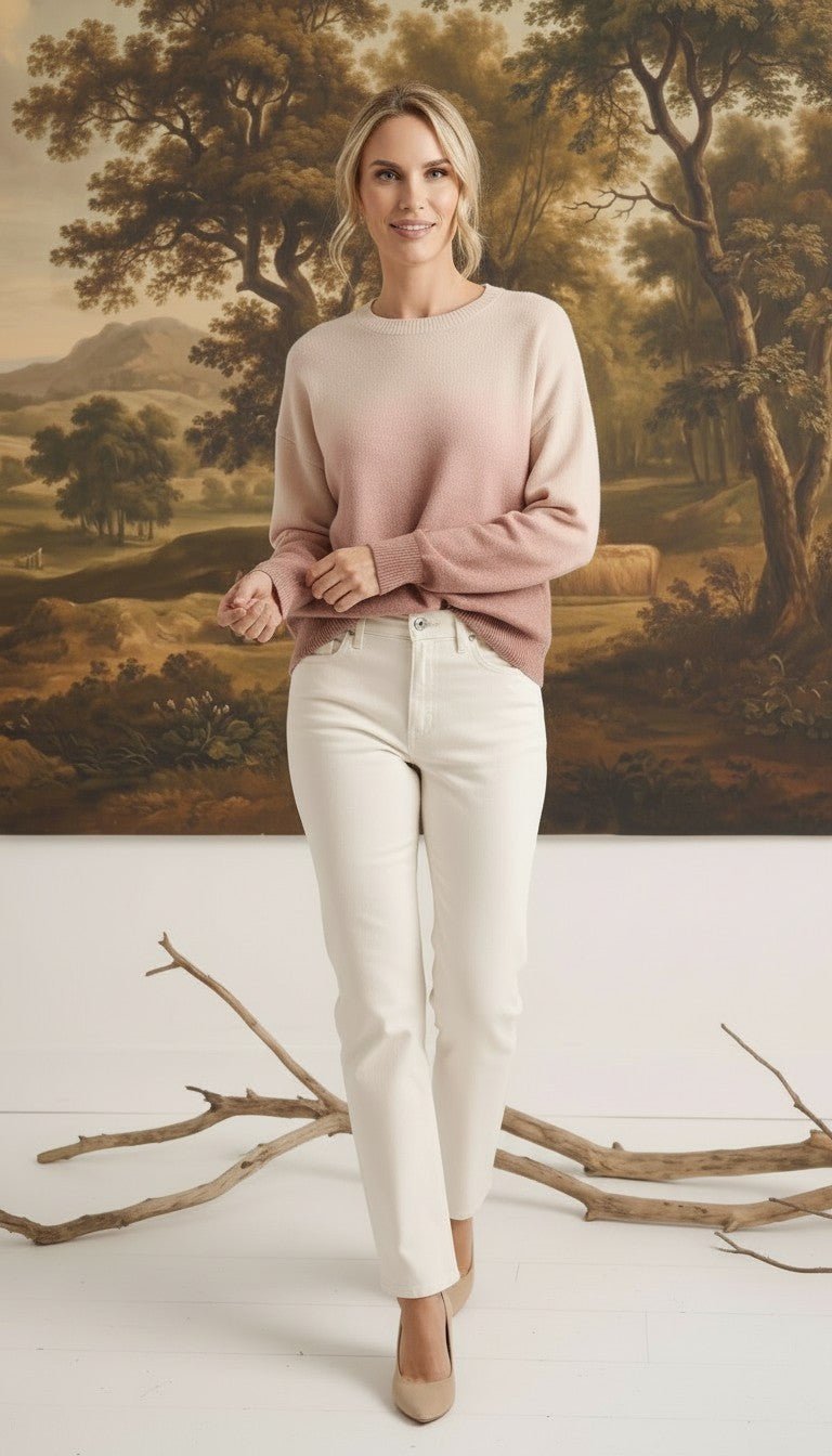graced The Joan Gradient Sweater in soft pink and cream, worn by a model with white jeans in a studio setting.