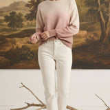 graced The Joan Gradient Sweater in soft pink and cream, worn by a model with white jeans in a studio setting.