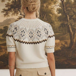 Back view of a woman wearing the graced Josephine Faire Isle Top, a cream short-sleeve knit with a brown geometric pattern
