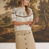 graced The Josephine Faire Isle Top in cream with brown and grey geometric patterns, worn with a beige midi skirt.