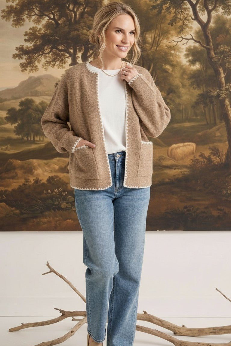 graced The Judy Open Cardigan in tan with white contrast stitching, worn by a model with jeans and a white top