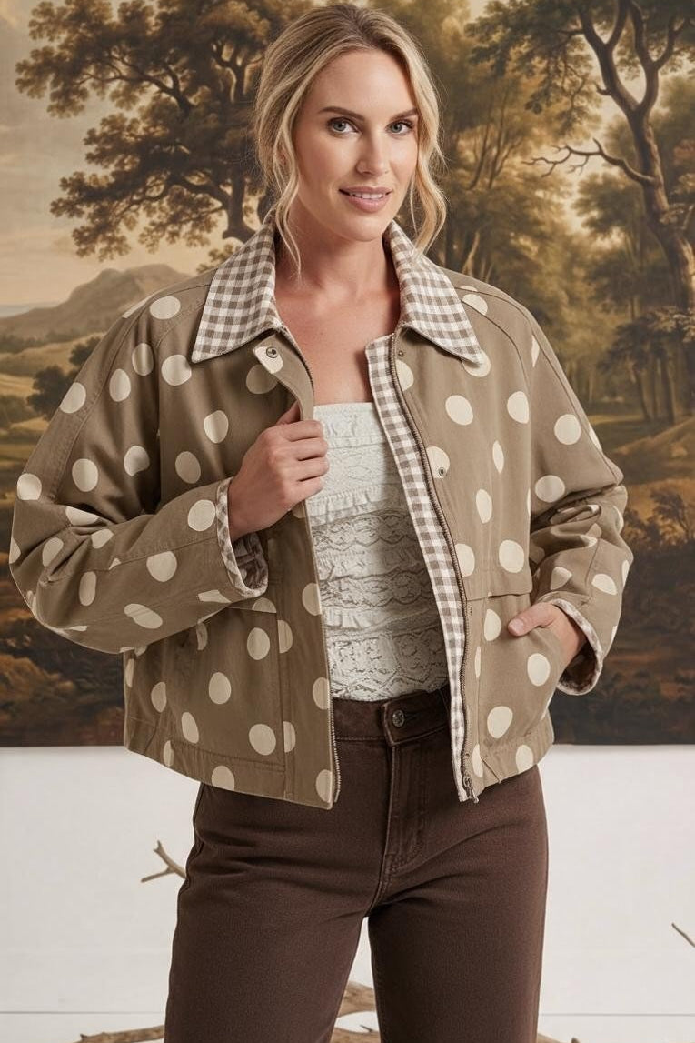 Model wearing a graced Julia polka dot canvas twill jacket in tan with a gingham collar, styled over a white top.