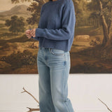 Model wearing a graced denim blue sailor-inspired knit sweater with a round neck and relaxed fit