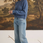 graced The Kaitlyn Sailor Sweater in denim blue with a round neck and knit texture, worn by a model with jeans.