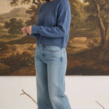 graced The Kaitlyn Sailor Sweater in denim blue with a round neck and knit texture, worn by a model with jeans.