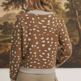 Back view of a woman wearing a graced Kathy brown knit sweater with a white deer pattern and ribbed trim