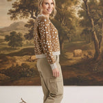graced Kathy sweater in brown with white deer pattern, worn by a woman with khaki cargo pants and beige loafers