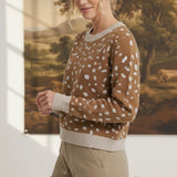 graced Kathy sweater in brown with white deer pattern, featuring a crew neck and ribbed trim, worn by a blonde model