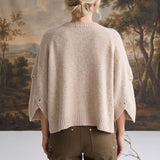 Back view of a model wearing the graced Layla taupe button sleeve top with a relaxed fit and ribbed hem