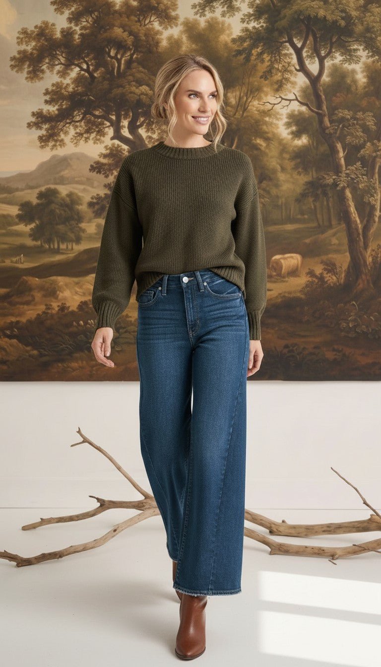 graced The Lily wide leg jeans in dark blue denim paired with an olive green sweater on a model