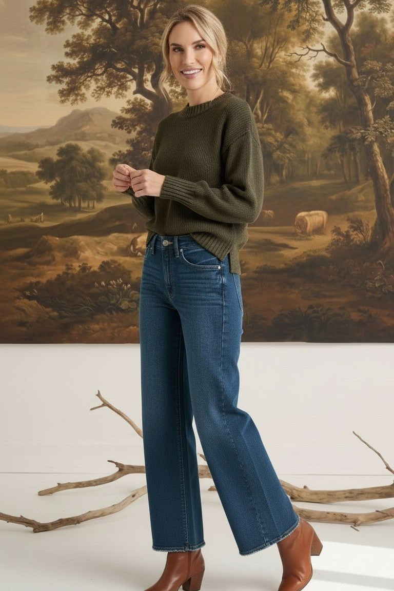 graced model wearing The Lily high-waisted wide leg blue denim jeans with a dark green sweater and brown boots