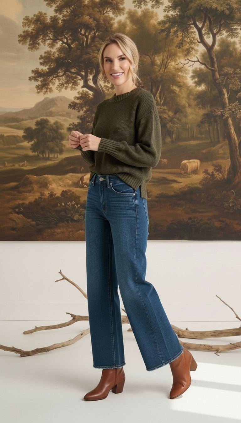 graced model wearing The Lily high-waisted wide leg blue denim jeans with a dark green sweater and brown boots