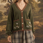 graced Lola cardigan in olive green with floral embroidery on pockets, worn over a plaid skirt by a blonde model
